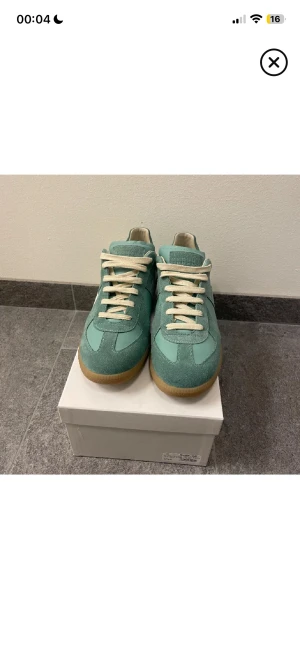 Mintgröna sneakers med mockadetaljer - Fräscha mintgröna sneakers med snygga paneler i mocka och skinn, samt vita snören och gummisula i beige. Skorna har en klassisk rund tå och platt sula, perfekt för dig som gillar stilrena och unika färger. Passar dig som vill sticka ut med dina sneakers.