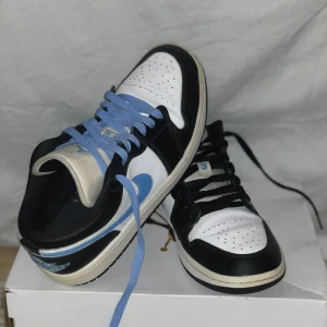Nike Air Jordan 1 Low UNC blue white and black med två par skosnören! - Säljer mina länge älskade Nike air Jordan 1 low universety blue white and black, som är i mycket fint skick! Kommer med två par skosnören så att man kan välja om man vill ha blåa(tillköpta för 300 förut) eller svarta(original). Ser lite gulare ut på bilderna än i verkligheten då jag har en gul lampa men men… Otroligt sköna och utan tvekan de snyggaste Jordan 1sen som finns. 