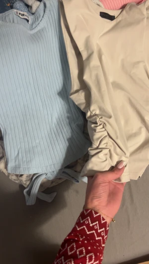 Ljusblå ribbad topp med knyt från Faster - Supersöt ljusblå topp med ribbat tyg och korta ärmar. Toppen har en croppad passform och snygg knytning i midjan som ger en extra detalj. Perfekt att styla med jeans eller kjol för en fräsch look.2 st 