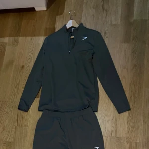  Gymshark träningset - Mörkgrön träningset från Gymshark med elastisk  och diskret logga på låret.. Snygg, smal passform o allmänt skön. 