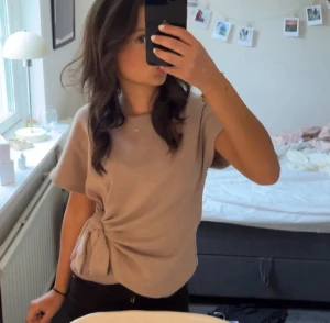 Beige topp med knyt i sidan - Aäljer en beige topp från Zara i storlek s väldigt bra skick förutom en tråd se sista bilden men inget som syns när man har den på  sig ❤️passad både s och xs 