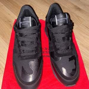 Valentino Garavani svarta sneakers - Säljer svarta camofluage valentino rockrunners. Skicket är som nyköpt. Anledningen jag säljer är jag har en andra skor som jag tycker mer om. Skriv vid intresse, öppen för förhandling. 