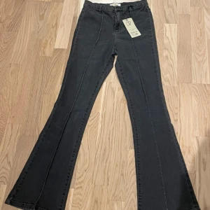 Gråa Bianca Flare Seam jeans DW - Snygga gråa Bianca Flare Seam jeans från DW med hög midja och utsvängda ben. 