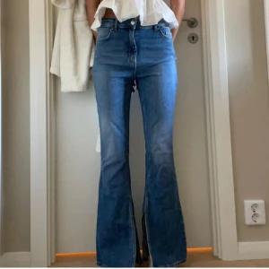 Blå bootcut jeans med slits - Snygga blå jeans med bootcut-modell och slits. Storlek är 32 och jag är 171 cm! Jeans tyget är lite ”stretchigt” därmed sitter de väldigt skönt och inte stelt mot kroppen