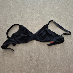 Behå - Snygg svart behå från Triumph i storlek 75B. Klassisk trekantsform med justerbara axelband och enkel knäppning i ryggen. Tillverkad i mjukt och följsamt material som sitter skönt och ger bra stöd.