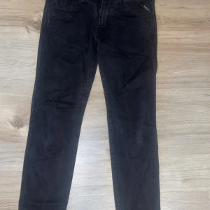 Replay svarta jeans, storlek 32 - Svarta jeans från Replay i klassisk femficksmodell. Snygg slim passform med normal midja och diskreta Replay-detaljer vid fickan. Jeansen är tillverkade i ett mjukt bomullsmaterial med lite stretch för extra komfort. Perfekt för dig som gillar stilrena och tidlösa jeans.