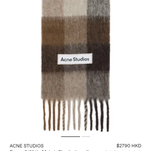 Rutig halsduk Acne Studios i ull - Snygg rutig halsduk från Acne Studios i mjuk ullmix med stora blockrutor i beige, grått, vitt och brunt. Klassisk design med fransar i ändarna och Acne Studios-logga framtill. Perfekt att slänga över axlarna för en cool look.