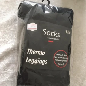 Svarta thermo leggings S/M - Thermo leggings i svart från MM Socks, perfekta för kalla dagar. De är tillverkade av 95% polyester och 5% elastan, vilket gör dem stretchiga och bekväma. Insidan är borstad för extra värme och mjuk känsla. Snyggt och enkelt plagg för dig som vill hålla dig varm.