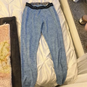 Blå mönstrade tights från Röhnisch - Snygga blå tights från Röhnisch med grafiskt mönster och bred svart resår i midjan med logga. Stretchigt material som sitter tight och är perfekta för träning eller chill. Passar dig som gillar sportig och modern stil.