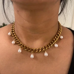 Guldiga halsband med droppformade pärlor - Matchande örhängen finns i en separat annons  Finns även i silverfärg   Material: 18K guldplätering på rostfritt stål Bredd: 9 mm Längd: 38-43cm Nickelfria och handgjorda.