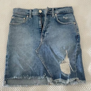 Blå jeanskjol från Pull&Bear  - Snygg blå jeanskjol från Pull&Bear i storlek S. Kjolen har fransad nederkant. I fint skick. Använd endast 2 gånger.