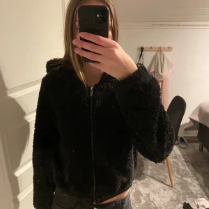 Svart teddyjacka från ONLY med huva - Mjuk och fluffig svart teddyjacka från ONLY med huva och dragkedja framtill. 