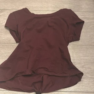 Vinröd kortärmad topp - Säljer en enkel och snygg vinröd topp med korta ärmar. Toppen har rund halsringning och är tillverkad i mjukt bomullsmaterial. Passformen är normal och färgen är djup vinröd, perfekt för dig som gillar stilrena plagg.