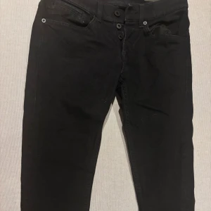 Svarta Dondup jeans, skinny fit stl 30 - Svarta jeans från Dondup, modell skinny fit. Klassiska fasion jeans med knappgylf. Diskret D-logga på bakfickan. Skriv via intresse och dom är skinny som sagt. 
