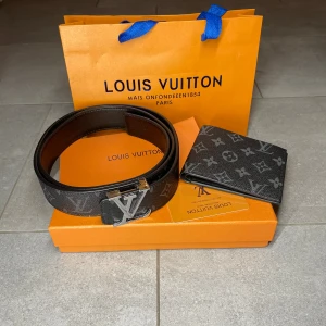 bälte med matchade plånbok - Snyggt svart bälte med klassiskt monogrammönster. Bältet är brett och har en lyxig känsla, perfekt för att lyfta vilken outfit som helst. Kommer med originalförpackning.