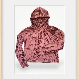 Rosa sammetshoodie från Gina Tricot - Supermjuk hoodie i glansig rosa sammet från Gina Tricot. Tröjan har huva, lång ärm och en loose fit som ger en chill vibe. Perfekt för dig som vill sticka ut med en cool och trendig look.