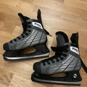 Svarta och grå skridskor från Pros stl 36 - Snygga skridskor från Pros i svart och grått med coolt mönster på sidorna och svarta snören. Modellen heter Max Power och har robust konstruktion med detaljer i syntetmaterial. Perfekta för isen när du vill sticka ut lite extra.