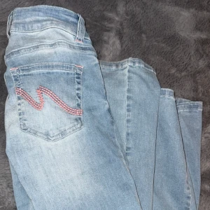 Bootcut jeans från Nelly, ljusblå med rosa fickor - Snygga ljusblå jeans från Nelly med rosa detaljer på sömmarna💕. Strlk 32 men passar mig som har 34-36 i vanliga fall, stretchiga, nästan aldrig använda🥰nypris 699