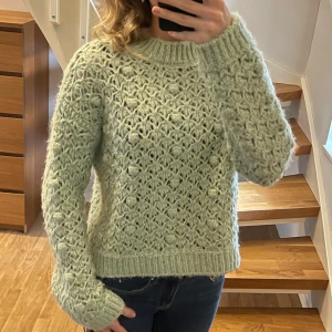 Ljusgrön stickad tröja från mango - Superfin ljusgrön stickad tröja från mango med  hålmönster och små bollar i strukturen. Tröjan har ribbade muddar och hög hals. Perfekt för höst och vinter🩵