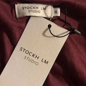 Vinröd oneshoulder topp från Stockh LM - Snygg vinröd topp från Stockh LM Studio i oneshoulder-modell med lång ärm. Tunn och mjuk kvalitet som känns skön mot huden. Färgen är djup vinröd och materialet har en lätt glans💕💕