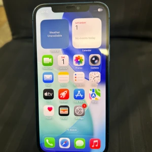 iPhone 12 64GB - Snygg iPhone 12 i blått med 64GB lagring. Telefonen är i gott skick med minimala tecken på användning. Uppdaterad till iOS 26.0.1. Dubbelkamera för skarpa bilder och Face ID. Perfekt för dig som vill ha en snabb och pålitlig mobil.