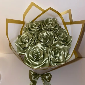 Eternal Roses / Evighets Rosor - Unik bukett med handgjorda gröna rosor i glansigt satinmaterial, snyggt arrangerade i ett vitt och guldigt omslag. Rosorna har en lyxig känsla och buketten är dekorerad med en matchande sidenrosett längst ner. Perfekt som present eller dekoration.