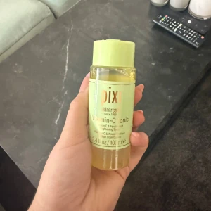 Pixi Vitamin-C Tonic toner 100 ml - Fräsch toner från Pixi med Vitamin-C, perfekt för att ge huden lyster och jämnare ton. Kommer i en genomskinlig plastflaska med ljusgrönt lock och etikett. Innehåller 100 ml och är enkel att använda i din hudvårdsrutin.