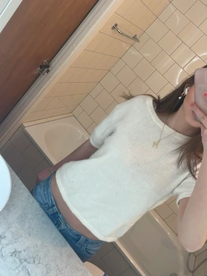 Vit croppad topp från Gina Tricot - Vit croppad topp med korta ärmar från Gina Tricot. Toppen har en boxig passform, ribbade detaljer vid halsringning och nederkant samt är tillverkad i stickad bomullsblandning. Enkel och fräsch stil som passar till jeans eller kjol.