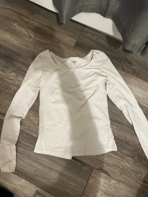 Vit långärmad topp från Lager 157 - En basic vit långärmad topp från lager 157 med rund halsringning. Tillverkad i mjukt bomullsmaterial, perfekt att styla till jeans eller kjol. Enkel och stilren design som funkar till många olika looks.