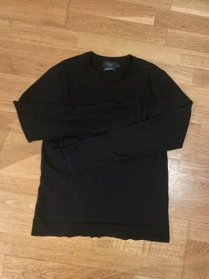 Svart stickad tröja från Riley - Klassisk svart stickad tröja från Riley i mjuk merinoull. Tröjan har rund halsringning och långa ärmar, perfekt för lager på lager. Enkel och stilren design som passar till det mesta. Pris kan diskuteras!!