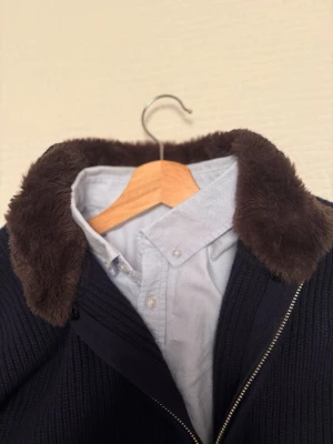 Pälscardigan - Säljer en cardigan med pälskrage från Sothiares, nypris 1800kr. Den är endast använd 2 gånger!!  Den är i storlek L men skulle säga att den också passar M. Pris går att diskutera!