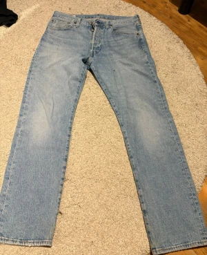 Levi's 501 ljusblå raka jeans - Klassiska ljusblå Levi's 501 jeans med rak passform och fem fickor. Jeansen har knappgylf, normal midja och är tillverkade i slitstark bomullsdenim. 