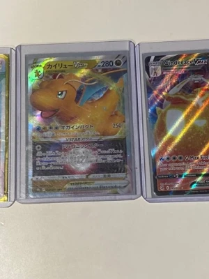Pokémonkort Dragonite VSTAR & Cinderace - Säljer två Pokémonkort: Dragonite VSTAR med holografisk yta och japansk text samt Cinderace VMAX med glittrig finish. Båda korten är i plastfickor och har färgstarka illustrationer. Perfekt för samlare eller dig som vill utöka din Pokémonkort-lek. Alla korten på bilderna är för salu