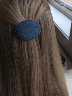 Jeansklämma till håret - Snygg hårklämma i blått jeanstyg med oval form. Perfekt accessoar för att ge frisyren en cool och trendig touch. Klämman är enkel att använda och passar till många olika hårstilar. Klämman är gjord av återvunna skedar och gamla jeans. 
