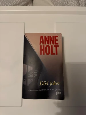 Död joker av Anne Holt - Spännande kriminalroman av Anne Holt med titeln 'Död joker'. Boken har ett omslag i mörka nyanser med röd och gul text. Pocketutgåva, tryckt på papper. Perfekt för dig som gillar deckare och nordisk spänning.