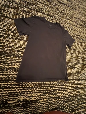 Marin blå t-shirt från BOSS - En stilren marin blå t-shirt från BOSS med diskret logga på bröstet. Klassisk rund halsringning och korta ärmar. Perfekt basplagg i garderoben och lätt att matcha till olika outfits.
