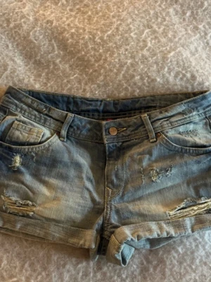Blå slitna jeansshorts - Säljer ett par blå jeansshorts pga att de inte passar mig. Midjemåttet är 40 cm, de är 22 cm långa fram och 33 cm i rumpan!  Skriv till mig om du har några frågor, pris kan såklart alltid diskuteras!❣️