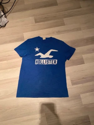 Hollister t-shirt  - Snygg blå t-shirt från Hollister i fint skick.