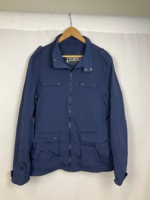 Herno Jacka  - Tja säljer en snygg blå jacka från Herno med krage och detaljer som dragkedjor och knappar framtill. Jackan är i väldigt fint skick och säljs för endast 1599kr. Nypris över 7000kr. Skriv vid frågor eller ifall du vill ha fler bilder. Storlek Large.