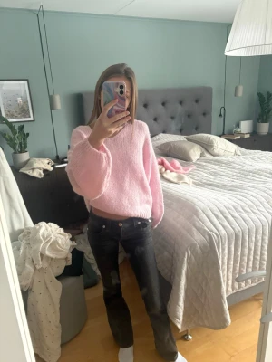 Svarta bootcut jeans med knappar - Säljer ett par svarta bootcut jeans med klassisk femficksdesign och knappar i midjan. Jeansen har en något utsvängd passform nertill och sitter snyggt över höfterna. Perfekta för dig som gillar en tidlös och trendig look.