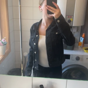 Svart jeansjacka med silvriga knappar - Säljer en svart jeansjacka me silverdetaljer. Säljer den pågrund av att den inte används. Har använt den 2 ggr så den är i fint skick och köpte den för 400 kroner.