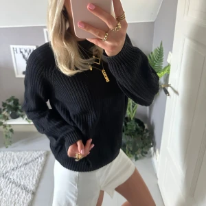 Svart stickad tröja - Säljer en svart stickad tröja med rund hals och långa ärmar. Tröjan har en ribbad struktur som ger en snygg och enkel look. Perfekt att matcha med både jeans eller kjol för en stilren vibe.