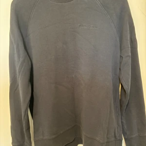 Mörkgrå sweatshirt från Peak Performance - Säljer en stilren mörkgrå sweatshirt från Peak Performance med diskret broderad logga på bröstet. Tröjan har rund hals, långa ärmar och är gjord i mjuk bomullsmix. Perfekt för en chill och avslappnad look.