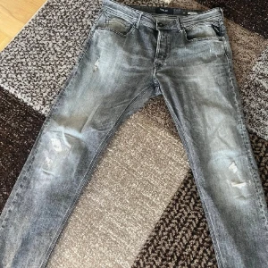 Gråa replay jeans - Aldrig använda kan gå ner i pris. Snygga grå jeans från Replay med slitna detaljer på benen och klassisk femficksdesign. Jeansen har en tvättad look och raka bakfickor med broderad detalj. Perfekta för dig som gillar en avslappnad och trendig stil. W36