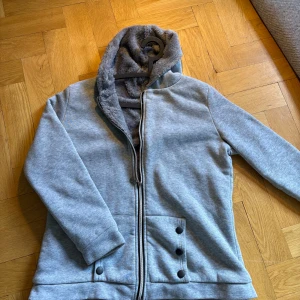 Grå päls hoodie - Säljer en riktigt skön grå päls hoodie. Skicket är 8,5/10 och i storleken är medium. Tveka inte att skriva ifall du har några frågor eller funderingar(: