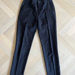 Svarta kostymbyxor J.Lindeberg stl 46 - Säljer ett par kostymbyxor från j.lindeberg i modellen sasha DS re flannel! Inte alls använda mycket nästan sprillans nya.  Material:Foder: 65% acetat, 35% polyester. Yttertyg: 98% virgin wool (ren ny ull), 2% elastan/spandex  Storlek:46 Nypris:1399  Skriv om ni har någon fundering om mått eller vad som!  Skicka gärna prisförslag svara alltid!!😊