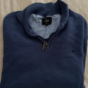 Marinblå stickad half zip från Park Lane - Snygg marinblå stickad tröja från Park Lane med half zip och hög krage. Tröjan har långärmade ärmar och diskret logga på bröstet. Perfekt för dig som gillar klassisk stil med en modern touch. Materialet är mjukt och håller värmen bra.