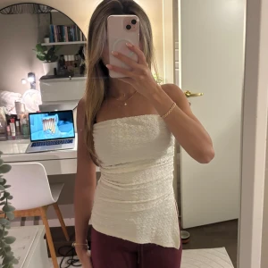 Tube topp  - En hit tubetopp med lite diskret mönster och en slit på sidan. Står ingen storlek i men skulle säga att det är en XS/S(kanske till och med M då det är väldigt strechigt material) Hör av dig om du har några frågor! 🫶🏼💕