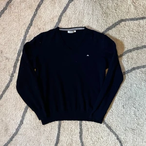 Marinblå v-ringad tröja J.Lindeberg XL men passar s - Klassisk marinblå v-ringad tröja från J.Lindeberg i storlek XL men är krympt till s. Utöver det är det inga defekter 