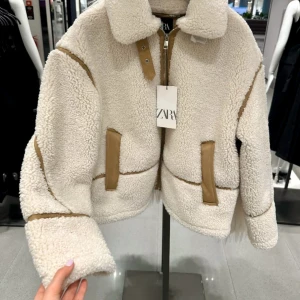 Beige teddyjacka från Zara - Säljer en supermjuk teddyjacka från Zara i beige med kontrasterande bruna detaljer. Jackan har dragkedja framtill, stora fickor och markerade sömmar. Oversized passform och långärmad med klassisk krage. Perfekt för kalla dagar när du vill vara både varm och snygg. Passar en S oxå 🩷💕kan diskutera pris